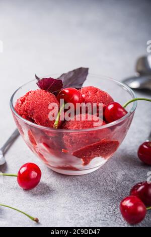 Palline di gelato al sorbetto di ciliegia biologica in vetro pronte a mangiare. Cibo biologico. Foto Stock