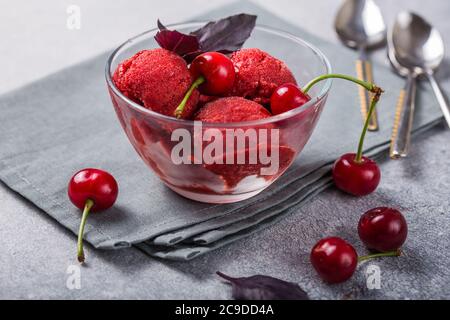 Palline di gelato al sorbetto di ciliegia biologica in vetro pronte a mangiare. Cibo biologico. Foto Stock