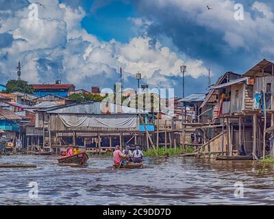 Belen, Perù - dicembre 2019: Persone sulle barche tra case galleggianti nella pianura alluvionale del fiume Itaya, la parte più povera di Iquitos - Belén. Venezia di la Foto Stock