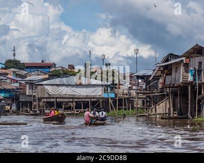 Belen, Perù - dicembre 2019: Persone sulle barche tra case galleggianti nella pianura alluvionale del fiume Itaya, la parte più povera di Iquitos - Belén. Venezia di la Foto Stock