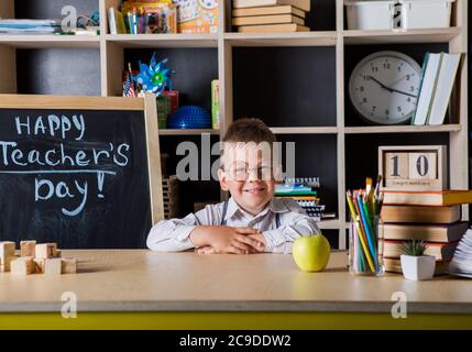 Bambino divertente in occhiali della scuola elementare. Scolaro studiando e casa Education.Teachers giorno. Foto Stock