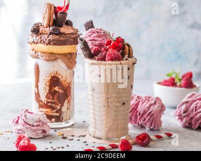 Frullato al cioccolato con frittella e ciambelle. Folle tendenza alimentare freakshake. Spazio di copia Foto Stock