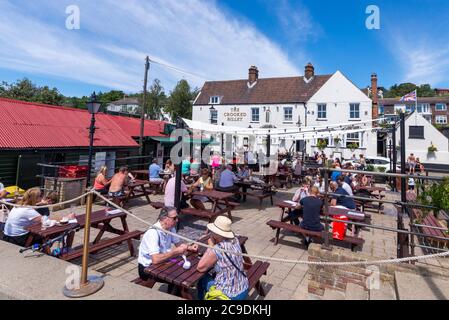 Il pub Crooked Billet, con relativi tavoli all'aperto per i clienti al di fuori di Billet Wharf. Occupato con i clienti durante il blocco COVID-19 Coronavirus Foto Stock
