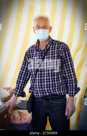 Un commerciante che indossa una maschera covid-19, al lavoro nonostante la crisi economica dovuta al coronavirus . Torino - Maggio 2020 Foto Stock