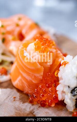 Piatti giapponesi, sushi fresco o sashimi a base di riso con salmone, avocado, cetriolo, caviale di pesce rosso, gamberi tempura da vicino Foto Stock