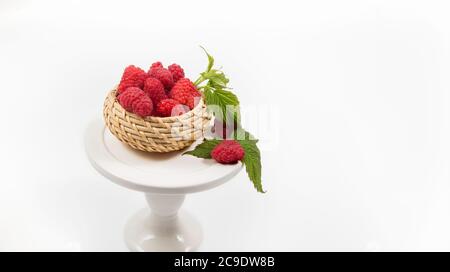 Lampone fresco e brillante in un cesto di vimini Foto Stock