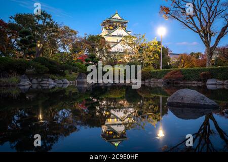 Castello di Osaka con giardino giapponese e riflessione in stagno nella stagione autunnale di notte a Osaka, Giappone. Giappone turismo, edificio di storia, o culto di tradizione Foto Stock