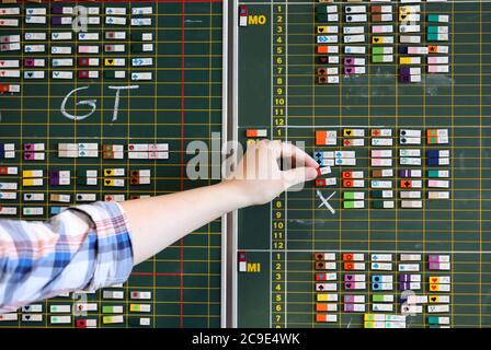 Rostock, Germania. 30 luglio 2020. Tommy Jeretzky, insegnante presso il Innerstädtisches Gymnasium Rostock ISG e responsabile della pianificazione, collega un magnete al tabellone magnetico, che contiene il calendario completo per tutte le classi e gli insegnanti. Meclemburgo-Pomerania occidentale è il primo stato federale del 03.08.2020 a riprendere il regolare funzionamento delle scuole a livello statale. Dopo le vacanze estive, nelle loro scuole sono attesi circa 150 studenti. Credit: Bernd Wüstneck/dpa-Zentralbild/dpa/Alamy Live News Foto Stock