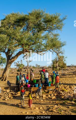 La gente locale che riceve acqua da un pozzo vicino al villaggio di Sangha nella scarpata di Bandiagara, paese di Dogon in Mali, Africa occidentale. Foto Stock