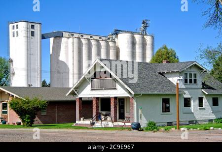 vista dall'autostrada 30 a sidney wyoming di piccole dimensioni tipiche town wyoming casa con elevatore di grano in background Foto Stock