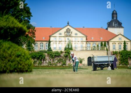 30 luglio 2020, Sassonia-Anhalt, Hundisburg: Giardiniere del paesaggio Anke Klaffehn erbacce in una broderie nel giardino barocco del Palazzo di Hundisburg. I primi edifici del Castello di Hundisburg furono già eretti nel XII secolo. Nel 1452 la famiglia von Alvensleben acquisì il complesso. Johann Friedrich von Alvensleben fece convertire l'Hundisburg in un palazzo barocco e stese il giardino barocco dell'architetto di Stato Braunschweig Hermann Korb alla fine del XVII secolo. Il Palazzo di Hundisburg e il giardino barocco fanno parte della rete 'Garden Dreams - Parchi storici in Sassonia-Anhalt' che ce Foto Stock