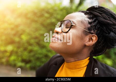 African Woman respirare aria pulita in natura con gli occhi chiusi Foto Stock