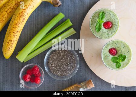 Frullato di banana al sedano con semi di chia e miele, servito con lamponi freschi e foglie di menta, vista ravvicinata dall'alto. Colazione sana, dessert, Foto Stock