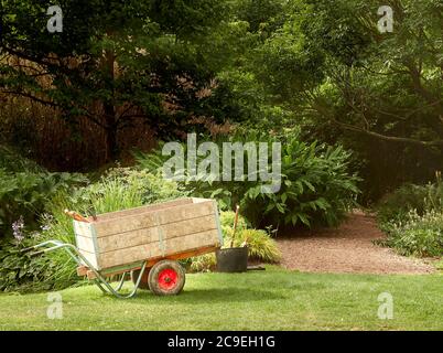 Carriola e attrezzi da giardinaggio presso il giardino botanico dell'università di Cambridge, Inghilterra. Foto Stock