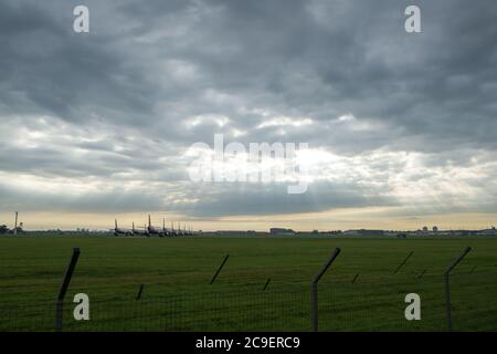 Glasgow, Scozia, Regno Unito. 31 luglio 2020. Nella foto: I raggi solari si infrangono attraverso le nuvole che brillano sulla collezione di aeromobili airbus British Airways (BA) con messa a terra delle varianti A319, A320 e A321 che sono collegati a terra all'aeroporto di Glasgow. Da quando la pandemia del coronavirus (COVID-19) ha colpito il Regno Unito, British Airways ha assimato un quarto del suo personale, e ha ritirato l'intera flotta di aeromobili Boeing 747 in un tentativo di ridurre i costi. Credit: Colin Fisher/Alamy Live News Foto Stock