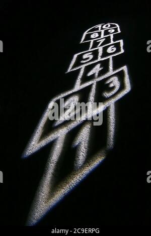 Campo da gioco illuminato per la partita di hopscotch durante la notte. Foto Stock