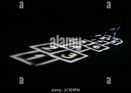 Campo da gioco illuminato per la partita di hopscotch durante la notte. Foto Stock