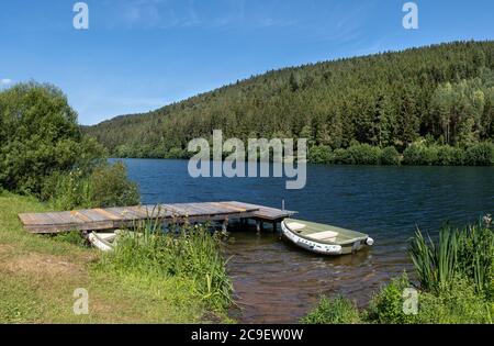 Molo in legno con barca su un lago Foto Stock