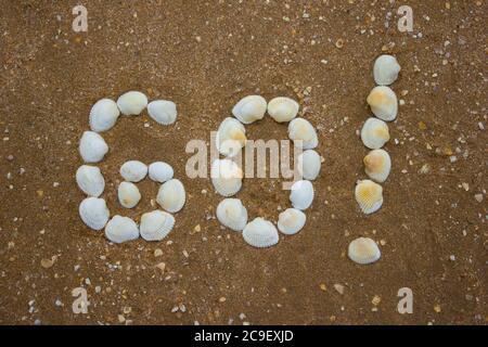 Iscrizione sulla sabbia da conchiglie - andare, campeggio, turismo Foto Stock