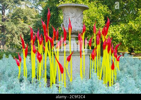 Kew Royal Botanical Gardens iconico Dale Chihuly Reflections Mostra colorati sculture in vetro scultura arte rosso giallo pennelli pietra urna Foto Stock