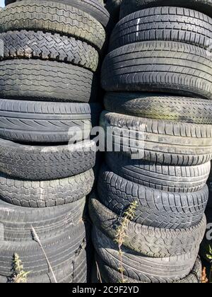 Pile o pile di vecchi pneumatici usati scartati nelle campagne in Germania, Europa occidentale Foto Stock