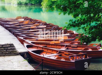 Parco Nazionale dei Laghi di Plitvice, Croazia. Linea di barche a remi ormeggiate a noleggio sulla riva del lago Kozjak. Il parco è un sito patrimonio dell'umanità dell'UNESCO. Foto Stock