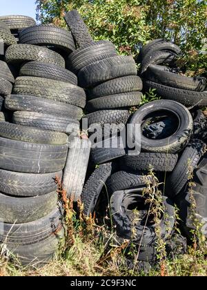 Pile o pile di vecchi pneumatici usati scartati nelle campagne in Germania, Europa occidentale Foto Stock