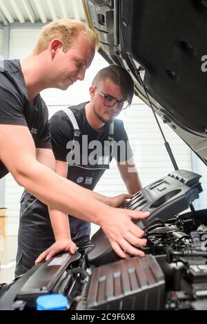 31 luglio 2020, Sassonia-Anhalt, Eilsleben: Rico Skiebe (l), apprendista di quarto anno tecnico di meccatronica automobilistica e suo fratello Justin Skiebe stanno di fronte a un motore presso la concessionaria di automobili Eilsleben. Justin Skiebe inizierà un apprendistato come tecnico di meccatronica dell'automobile là il 01 agosto 2020. Nel distretto della Camera di Commercio di Magdeburgo, il 1° agosto, un buon 820 apprendisti inizieranno la formazione nel settore. Questo è un buon dieci per cento in meno di un anno fa, ha annunciato la Camera del Commercio. Foto: Klaus-Dietmar Gabbert/dpa-Zentralbild/dpa Foto Stock