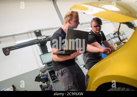 31 luglio 2020, Sassonia-Anhalt, Eilsleben: Rico Skiebe (l), un quadriennale tecnico di meccatronica automobilistica, e suo fratello Justin Skiebe stanno di fronte a un cofano aperto presso la concessionaria Eilsleben. Justin Skiebe inizierà un apprendistato come tecnico di meccatronica dell'automobile là il 01 agosto 2020. Nel distretto di Magdeburgo della Camera dei Mestieri, un buon 820 apprendisti inizieranno la formazione nel mestiere il 1 agosto. Questo è un buon dieci per cento in meno di un anno fa, ha annunciato la Camera del Commercio. Foto: Klaus-Dietmar Gabbert/dpa-Zentralbild/dpa Foto Stock