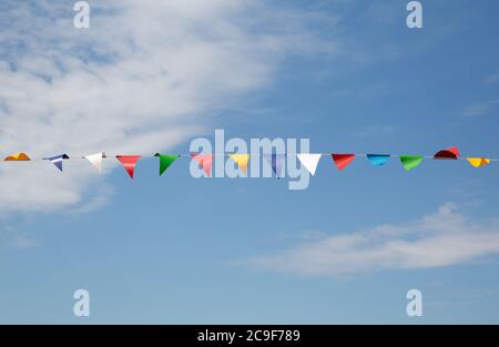 Bandiere triangolari colorate su sfondo blu del cielo Foto Stock