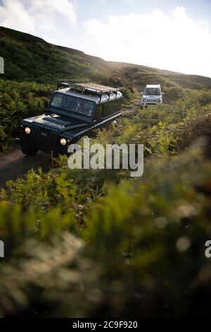 North Yorkshire Moors, UK - Luglio 23 2020: Land Rover Defender fuori strada su una corsia verde nel North Yorkshire Moors in Inghilterra. Foto Stock