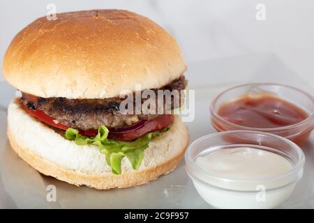 Hamburger perfetto hamburger classico hamburger, pomodoro e lattuga isolato su uno sfondo bianco Foto Stock