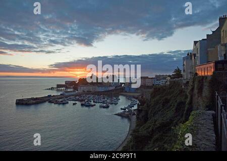 Il sole sorge sul porto nella località balneare di Tenby nel Galles del Sud-Ovest, Regno Unito. Foto Stock