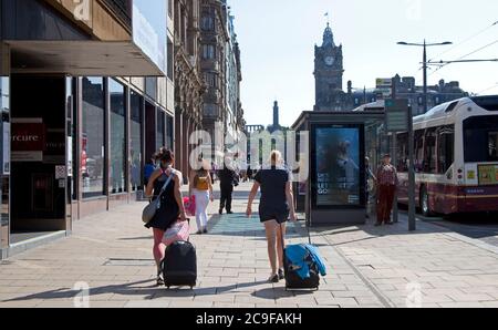 Edimburgo, Scozia, Regno Unito. 31 Gianni 2020. Giorno caldo a Edimburgo 22 gradi centigradi entro mezzogiorno con sole frizzante per i turisti che arrivano con i loro bagagli e che visitano il centro della città. Foto Stock