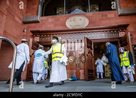 I fedeli osservano le distanze sociali quando arrivano alla Grande Moschea di Bradford, a Bradford, nello Yorkshire occidentale, il primo giorno di Eid, una delle aree in cui sono state attuate nuove misure per prevenire la diffusione del coronavirus. Sono state introdotte norme più severe per le persone nella Greater Manchester, in alcune zone del Lancashire orientale e nello Yorkshire occidentale, che vietano ai membri di famiglie diverse di incontrarsi in luoghi chiusi. Foto Stock