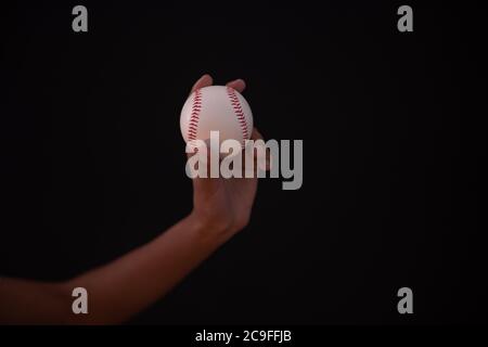 Persona che tiene il baseball in mano Foto Stock