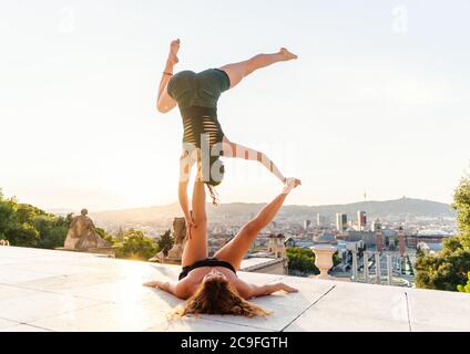 Due belle donne che fanno acroyoga in città Foto Stock