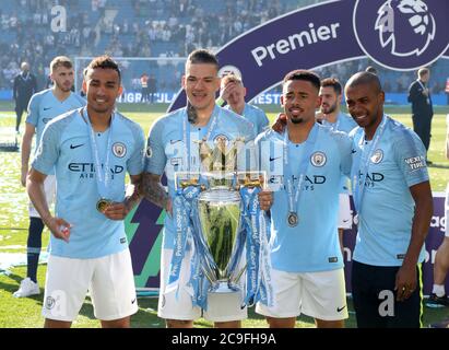 Il portiere di Manchester City, Ederson, tiene il Premier League Trophy con il Danilo di Manchester City (a sinistra) Gabriel Jesus di Manchester City e il Fernandinho di Manchester City (a destra) durante la partita della Premier League all'AMEX Stadium di Brighton. Foto Stock