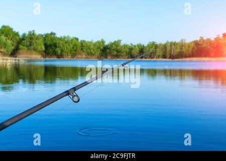 Canna da pesca sulla barca. Una canna da pesca è una canna lunga e flessibile utilizzata dai pescatori per pescare. Pesca in estate Foto Stock