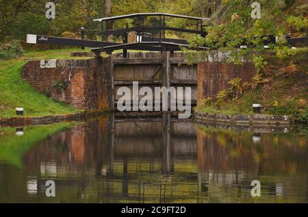 I cancelli di serratura sono chiusi e riflessi nell'acqua in questa scena di inizio autunno sul canale di Basingstoke in Surrey Foto Stock