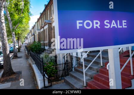 Cartello agenzia immobiliare 'IN VENDITA' su via di case Foto Stock