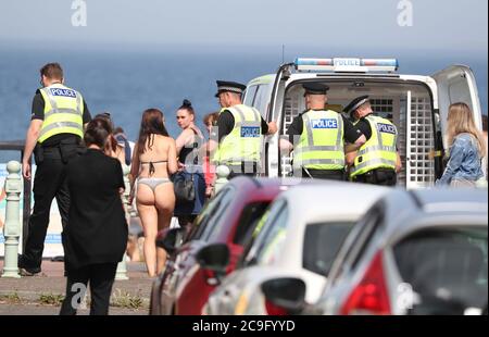 Polizia a Portobello Beach a Edimburgo dove hanno rotto grandi folle che si sono accampati alla spiaggia per sfruttare al massimo il bel tempo. Foto Stock