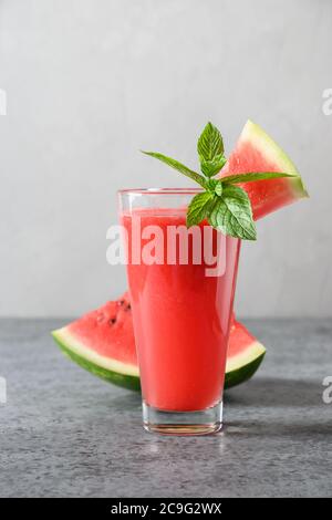 Bicchiere di cocktail di cocomero guarnire la menta su sfondo grigio. Primo piano. Foto Stock