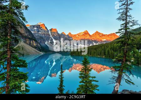 L'alba dorata sulla Valle delle dieci vette con il lago Moraine color turchese alimentato da ghiacciaio in primo piano vicino al lago Louise nella Roc canadese Foto Stock