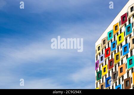 Architettura su uno sfondo di cielo blu con nuvole. Moderno sviluppo residenziale. Edificio residenziale di appartamenti con una facciata di colore luminoso, b Foto Stock