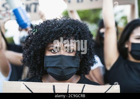 Attivista giovane donna afro che protesta contro il razzismo e la lotta per l'uguaglianza - Black Lives materia dimostrazione in strada per la giustizia Foto Stock