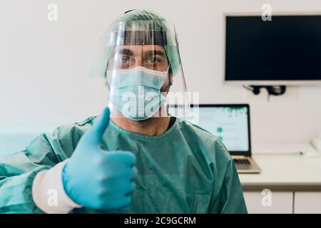 Medico che indossa la maschera chirurgica del viso ppe e visiera che combatte contro l'epidemia di virus corona Foto Stock
