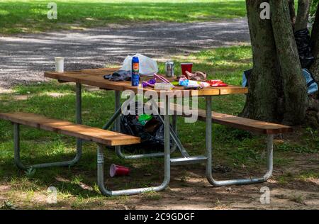 26 luglio 2020- Roxton Falls, QC, Canada: Rifiuti lasciare su un tavolo da picnic su un luogo di campeggio disordinato, parco pubblico Foto Stock