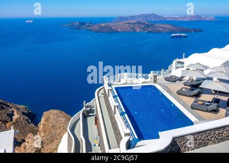 Grecia. Isola di Thira. Santorini. Hotel sulla riva alta di Oia. Piscina e sedie a sdraio per il relax in condizioni di sole. Stagcape Foto Stock