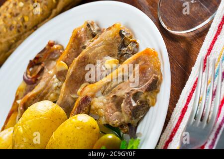 Costolette di mouton cotte lentamente con patate, piatto spagnolo Costillas de cordero Foto Stock